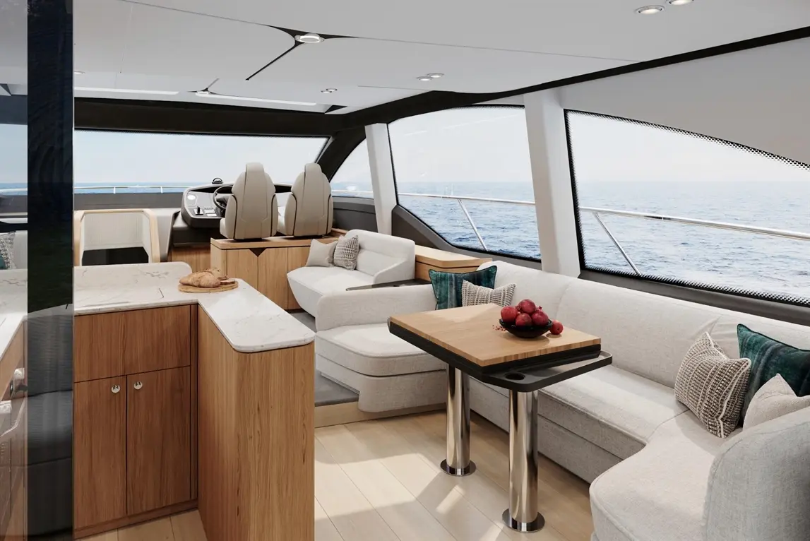 A modern yacht interior featuring plush seating, a dining table with a bowl of red apples, and panoramic sea views.